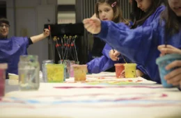 Kinder an einem Tisch mit Malutensilien