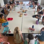 Kinder, die am Arabisch-Unterricht der Syrischen Gemeinschaft Bremen teilnehmen, sitzen um einen großen Tisch