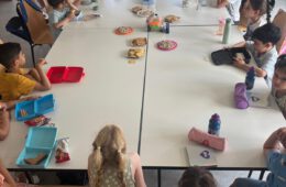 Kinder, die am Arabisch-Unterricht der Syrischen Gemeinschaft Bremen teilnehmen, sitzen um einen großen Tisch